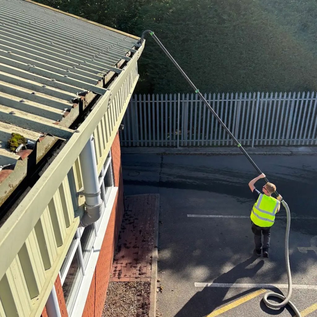 Man uses vacuum to clean gutter- Bristol Pressure Washing