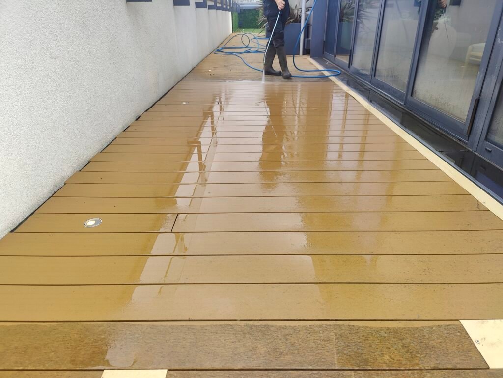 Composite decking walkway on a Bristol roof terrace, part cleaned, showing the difference against the untouched section
